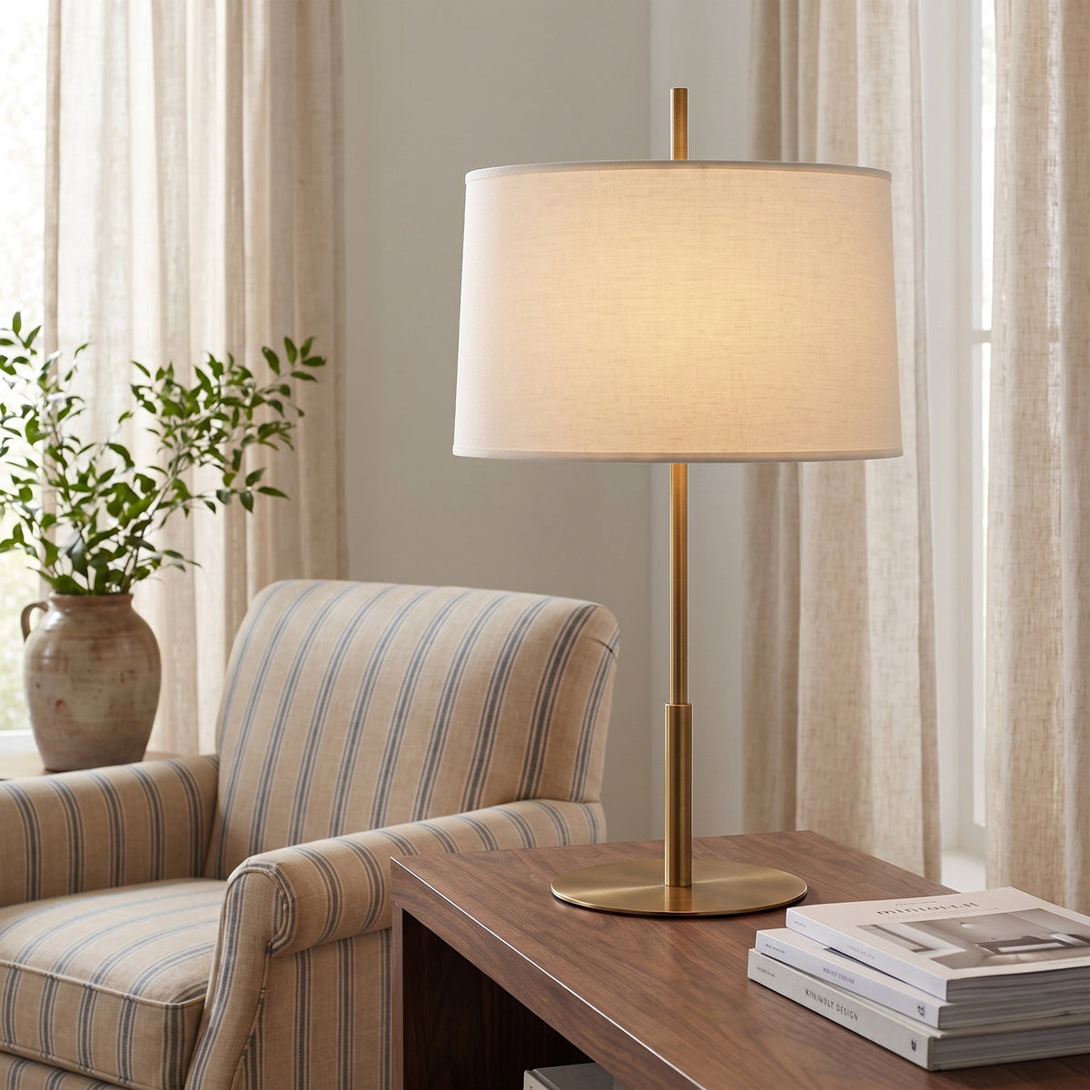 Novara Table Lamp in Lacquered Burnished Brass beside an armchair